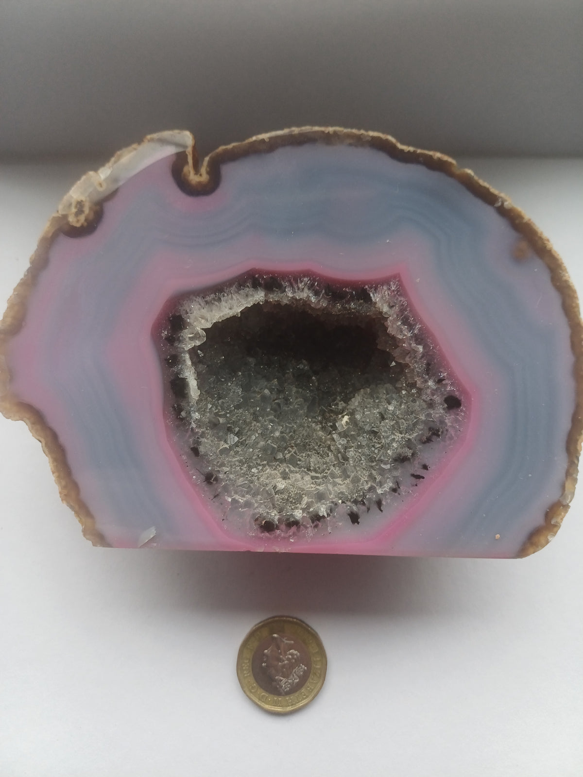 Detailed view of blue-grey and pink agate banding around a druzy quartz centre