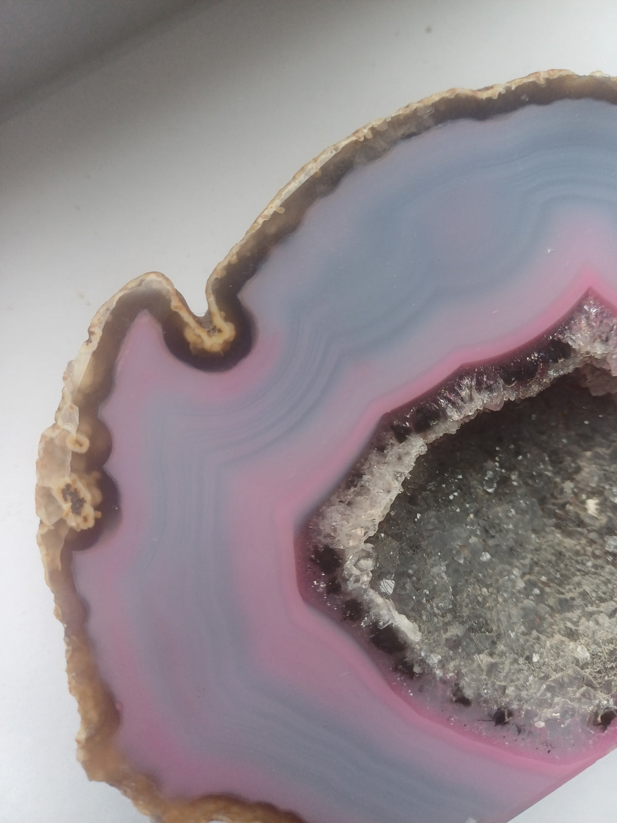 Pink and blue agate druzy geode section shown with a UK one pound coin for scale