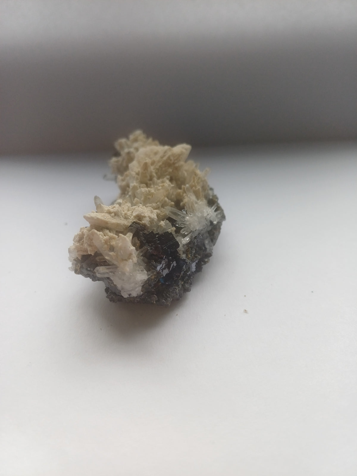 Mixed mineral specimen front view with dark metallic crystals, clear quartz sprays and cream crystal matrix