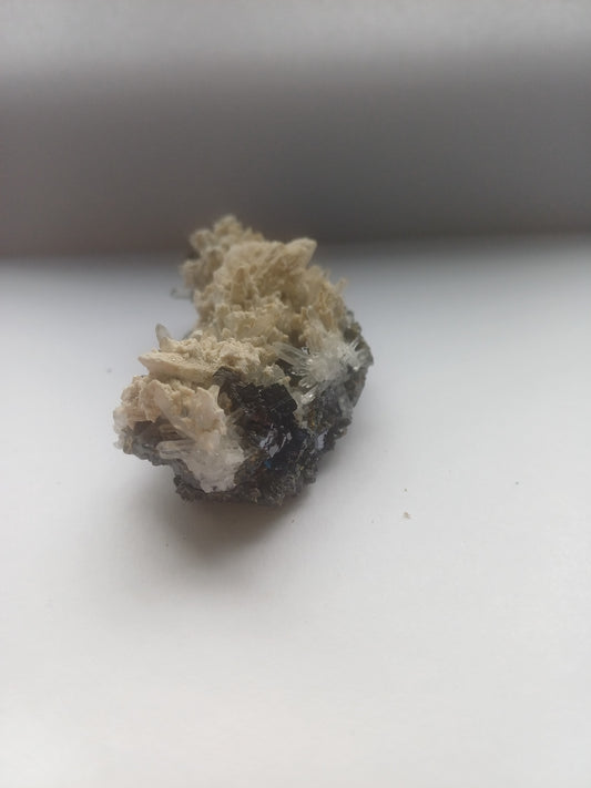 Mixed mineral specimen front view with dark metallic crystals, clear quartz sprays and cream crystal matrix