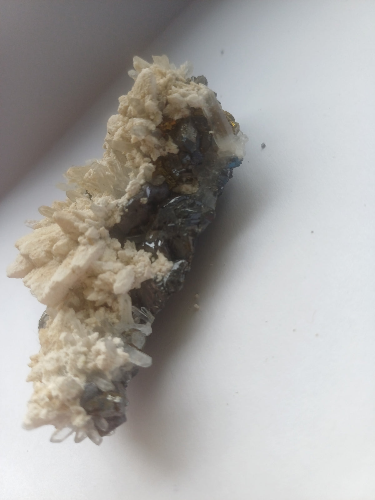 Mixed mineral specimen side view showing dark crystalline base with pale matrix and clear quartz points